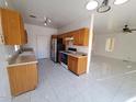 Kitchen with wood cabinets, tiled floor, and view into adjacent living area at 7402 S 40Th Ln, Phoenix, AZ 85041