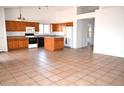 Open kitchen with oak cabinets, island, and tile floor at 7571 W Pasadena Ave, Glendale, AZ 85303