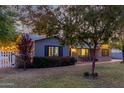 Well-maintained house with a lush green lawn, inviting porch, and mature trees at 819 W Solano Dr, Phoenix, AZ 85013