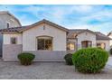 House exterior showcasing a neutral color scheme, well-maintained landscaping, and a two-car garage at 19371 E Carriage Way, Queen Creek, AZ 85142