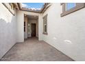 Covered entryway with brick flooring and a dark brown door at 4779 N 205Th Gln, Buckeye, AZ 85396