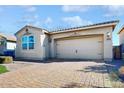 Attractive tan house with a paved driveway and two-car garage at 30855 N 138Th Ave, Peoria, AZ 85383