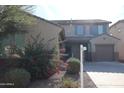 Two-story house with taupe exterior, two-car garage, and landscaping at 10551 W Crown King Rd, Tolleson, AZ 85353