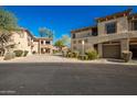 Two-story building with tan exterior, attached garages, and landscaping at 19700 N 76Th St # 2135, Scottsdale, AZ 85255