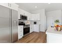 Modern kitchen with stainless steel appliances and white cabinetry at 20236 W Highland Ave, Litchfield Park, AZ 85340