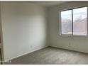 Simple bedroom with carpet flooring and a large window at 22130 N Van Loo Dr, Maricopa, AZ 85138