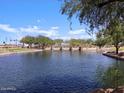 Tranquil lake with walking paths and scenic landscaping at 36834 W La Paz St, Maricopa, AZ 85138