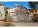 Two-car garage with a light-colored stucco exterior at 43842 W Elizabeth Ave, Maricopa, AZ 85138