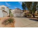 Exterior view showcasing a two-car garage and driveway at 43842 W Elizabeth Ave, Maricopa, AZ 85138