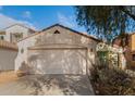 House exterior with a two-car garage and mature tree at 43842 W Elizabeth Ave, Maricopa, AZ 85138