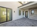 Private back patio with modern sliding glass door and stone accent wall at 9872 W Black Hill Rd, Peoria, AZ 85383