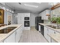 Spacious kitchen featuring an island, white cabinets, and black appliances at 215 N Power Rd # 361, Mesa, AZ 85205