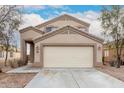 Tan two-story home with attached two-car garage and desert landscaping at 21869 W Mohave St, Buckeye, AZ 85326