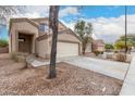 Two-story home with attached two-car garage, desert landscaping, and a tree at 21869 W Mohave St, Buckeye, AZ 85326