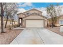 Tan two-story home with attached two-car garage and desert landscaping at 21869 W Mohave St, Buckeye, AZ 85326