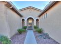 Front entry with arched doorway and walkway between two walls at 42575 W Abbey Rd, Maricopa, AZ 85138