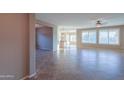Open living room with tile floors and views into kitchen area at 42575 W Abbey Rd, Maricopa, AZ 85138