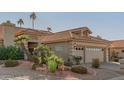 Tan two-car garage home with tile roof and manicured desert landscaping at 10929 E Spring Creek Rd, Sun Lakes, AZ 85248