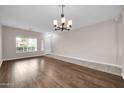 Spacious living room featuring hardwood floors and a chandelier at 14527 W Gelding Dr, Surprise, AZ 85379