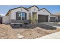 Newly built home with a two-car garage and drought-tolerant landscaping at 17751 W Carol Ave, Waddell, AZ 85355