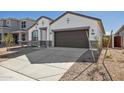 New construction home with a two-car garage and desert landscaping at 17751 W Carol Ave, Waddell, AZ 85355