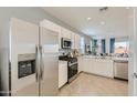 Stainless steel appliances and white cabinets in this open concept kitchen at 15658 W Winslow Ave, Goodyear, AZ 85338