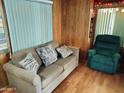 Living room with sofa, recliner, and wood-paneled walls at 306 S Recker Rd # 145, Mesa, AZ 85206