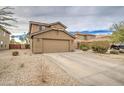 Two-story house with tan exterior, two-car garage, and desert landscaping at 274 S 18Th St, Coolidge, AZ 85128