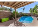 Inviting backyard oasis with a sparkling pool, covered patio, and lush landscaping at 13852 N 91St Ln, Peoria, AZ 85381