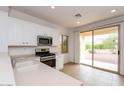 Kitchen with white cabinets, stainless steel appliances, and access to backyard at 22409 N Los Gatos Dr, Sun City West, AZ 85375
