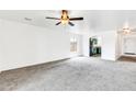 Spacious living room with neutral carpeting and ceiling fan at 25370 W Jackson Ave, Buckeye, AZ 85326