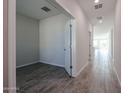 Bright hallway with grey tile floors and access to other rooms at 35595 W Mallorca Ave, Maricopa, AZ 85138
