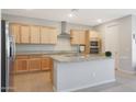 Modern kitchen with light wood cabinets, granite countertops, and stainless steel appliances at 15072 W Mckinley St, Goodyear, AZ 85338