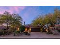 Two-story home with a tile roof, desert landscaping, and a two-car garage at sunset at 9472 E Whitewing Dr, Scottsdale, AZ 85262