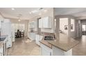 Bright kitchen with white cabinets, an island, and a breakfast nook at 16502 W Arroyo Ct, Surprise, AZ 85374