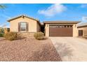 One-story home with brown garage door, and landscaped yard at 17830 W Pinnacle Vista Dr, Surprise, AZ 85387