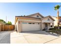 Tan house with a two-car garage, mature palm trees, and a wooden fence at 8371 W Pontiac Dr, Peoria, AZ 85382