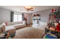 Cozy living room with a large sectional sofa, ceiling fan, and festive holiday decorations at 21956 W Casey Ln, Buckeye, AZ 85326