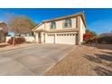 Two-story house with a three-car garage and desert landscaping at 6443 N 77Th Dr, Glendale, AZ 85303