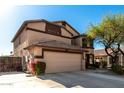 Tan two-story house with a two-car garage and mature landscaping at 6801 W Rowel Rd, Peoria, AZ 85383