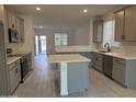 Modern kitchen featuring gray cabinets, quartz countertops, and island at 17065 W Seldon Ln, Waddell, AZ 85355