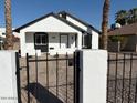 Renovated home with a white exterior, black accents, and a gated entryway at 2114 W Washington St, Phoenix, AZ 85009