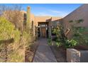Front entrance with a wooden door and desert landscaping at 26639 N 132Nd St, Scottsdale, AZ 85262
