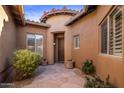 Inviting courtyard entry with flagstone pathway, potted plants, and a wooden door at 32051 N 73Rd Pl, Scottsdale, AZ 85266