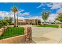 Front view of a luxurious home with a large driveway and a beautiful lawn at 8611 E Cholla St, Scottsdale, AZ 85260