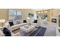 Bright living room featuring white sofas, a fireplace, and large windows at 11845 N 40Th Pl, Phoenix, AZ 85028