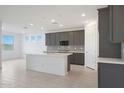 Open concept kitchen with gray cabinets and a large island at 14830 W El Cortez Pl, Surprise, AZ 85387