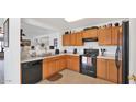 Well-equipped kitchen featuring wooden cabinets and black appliances at 15578 W Acapulco Ln, Surprise, AZ 85379