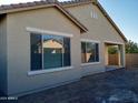 Tan stucco house with large windows and a covered patio at 21024 E Poco Calle St, Queen Creek, AZ 85142