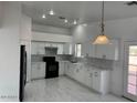 Modern kitchen featuring white cabinets, new appliances, and tile flooring at 2738 E Brill St, Phoenix, AZ 85008